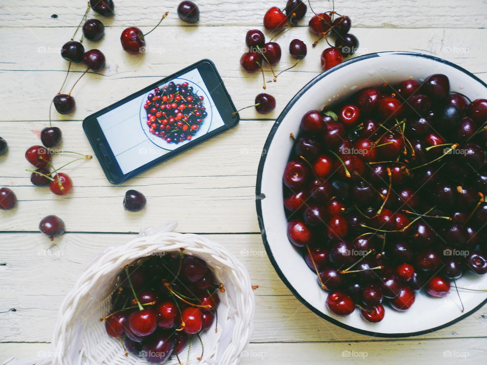 cherries and smartphone on a white background