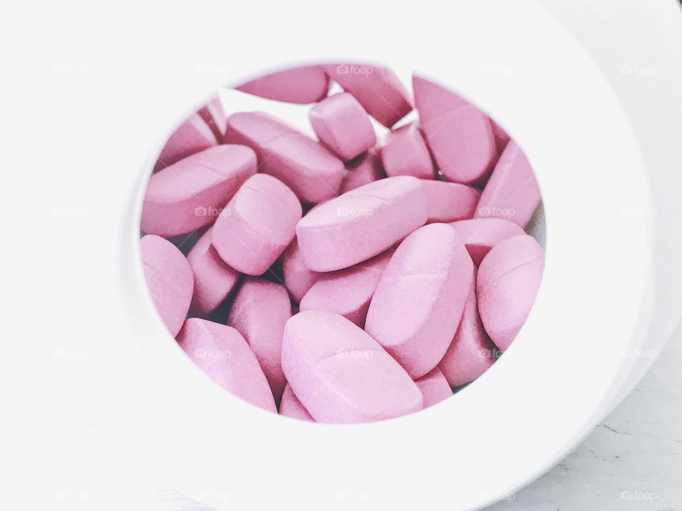 Vitamins pink tablet in bottle