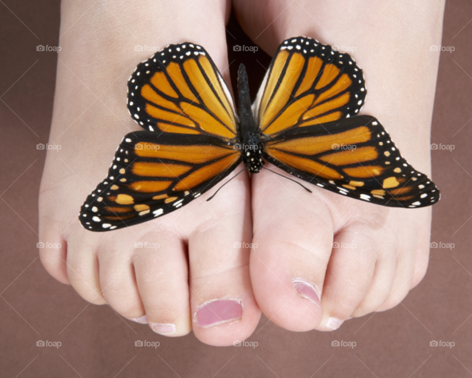 Nice baby feet with a red butterfly on it