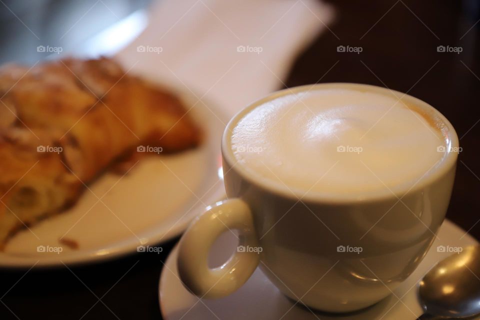 Cappuccino and croissant on tabletop 