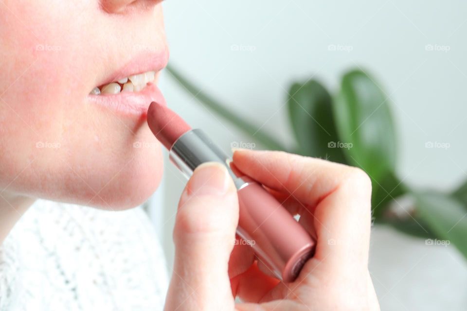 Woman is using lipstick