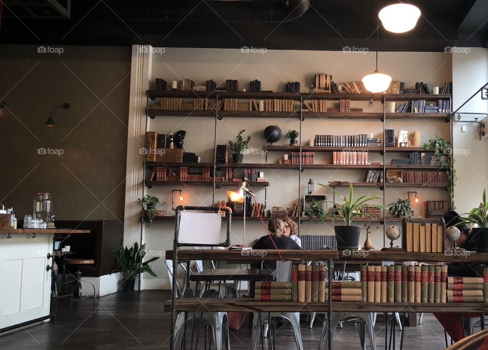 A wall of mismatched books set to catch the eye inside a quaint coffee shop 