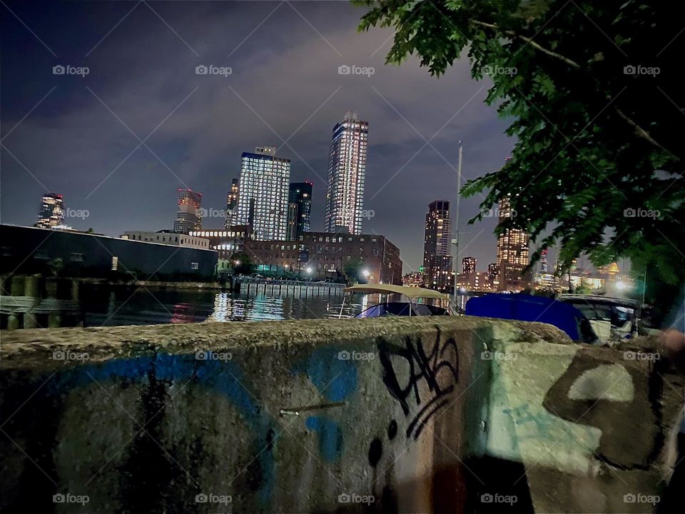 Illuminated by night the „East River“ at „Newtown Creek“ by the „Pulaski Bridge“ can be observed quite clearly still at this late hour. After a long stint at the laundromat we are now heading home. 2022. Hypnotic Productions. 💼