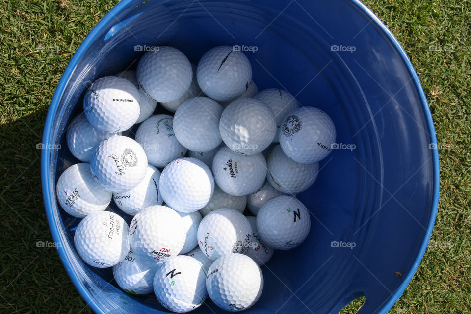 Golf balls on a bucket on the green