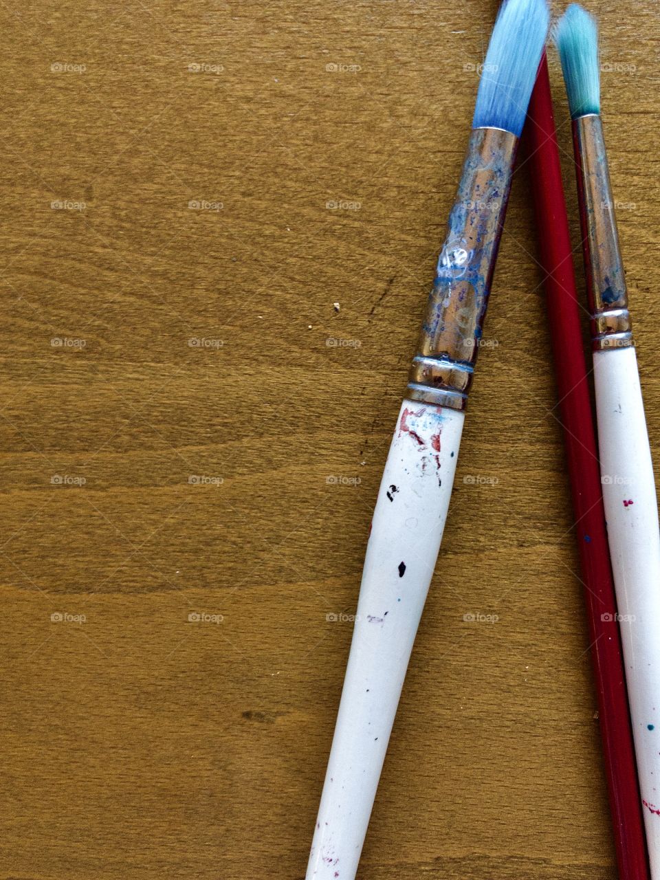 Used paintbrushes on wooden table 