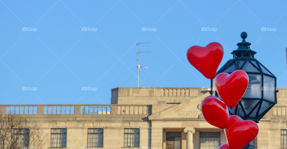 Heart shaped balloons and street light in city