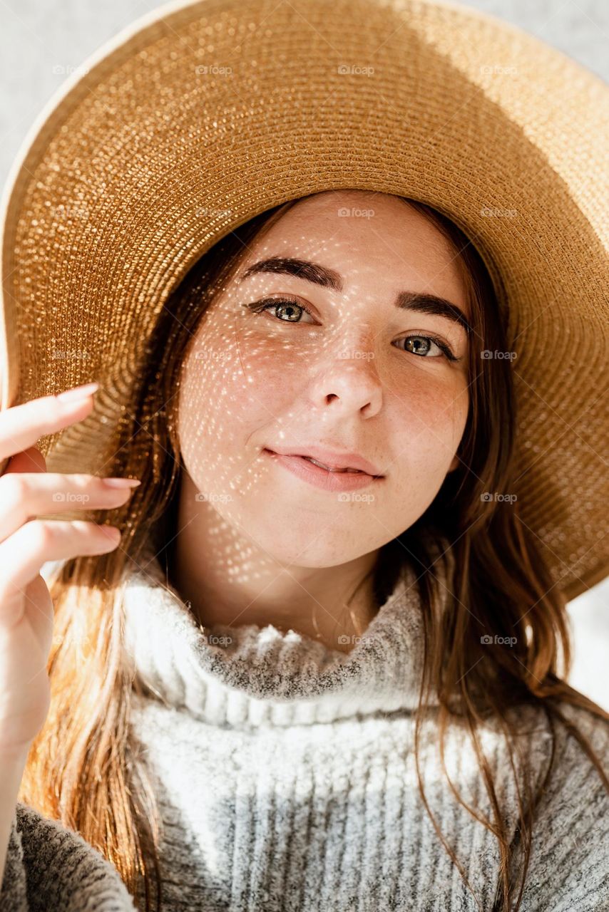 woman in hat with shadow overlay of face