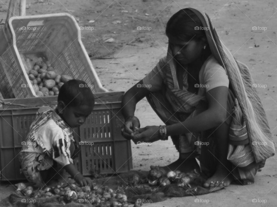 hardships of life. this mother and son lived on streets selling produce on road side. ...both support one another everyday