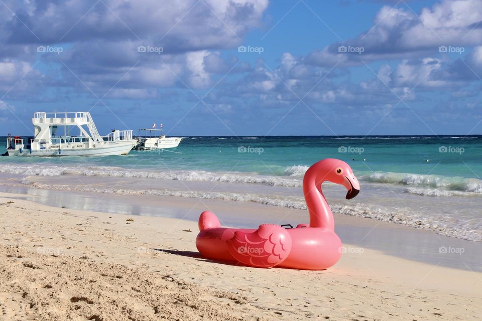 inflatable pink flamingo on the beach