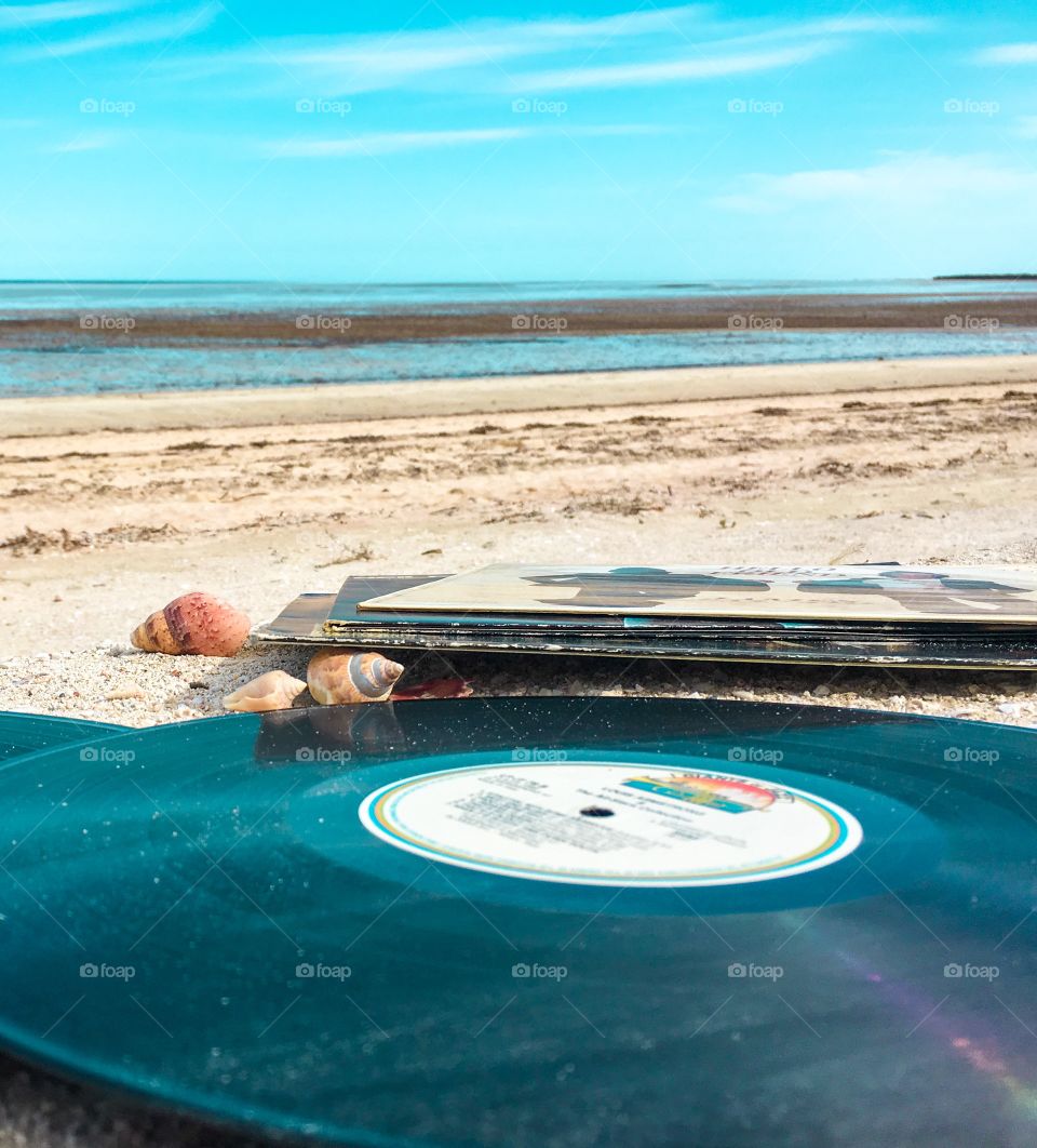 Vintage vinyl record on remote beach Aqua marine colours real