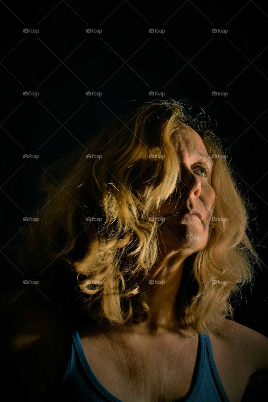 low key color portrait blond woman staring in the darkness