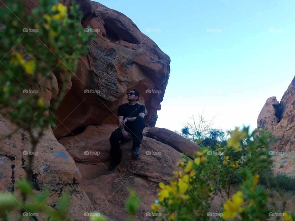 man seating on rock thinking