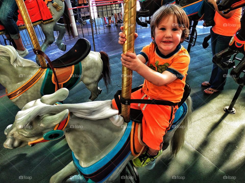 Young child riding a carousel