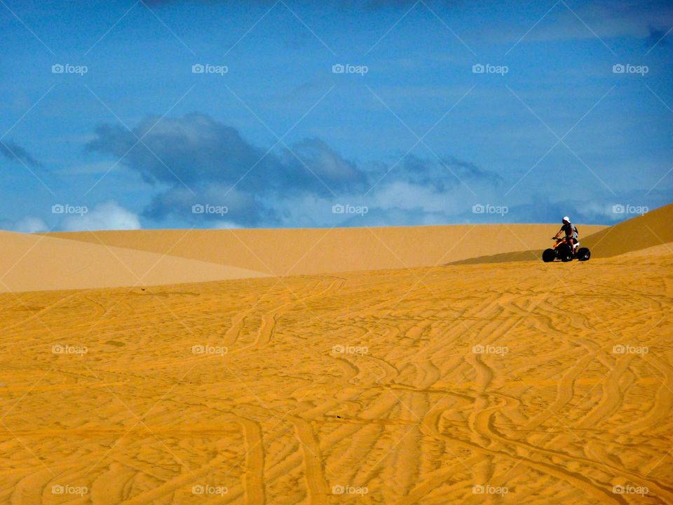 Doing a Quad Tour in the Red Dunes of Mui Ne, Vietnam. Very noisy, very evil-smelling, very hot - and a lot of fun.