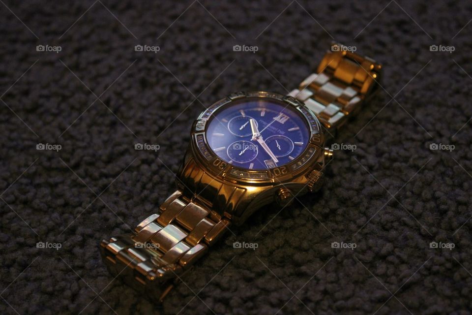 A golden watch waiting to be worn on a night out on the town