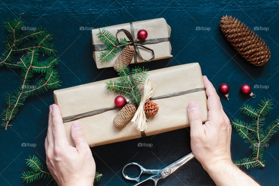 Hands of man decorating Christmas gift box