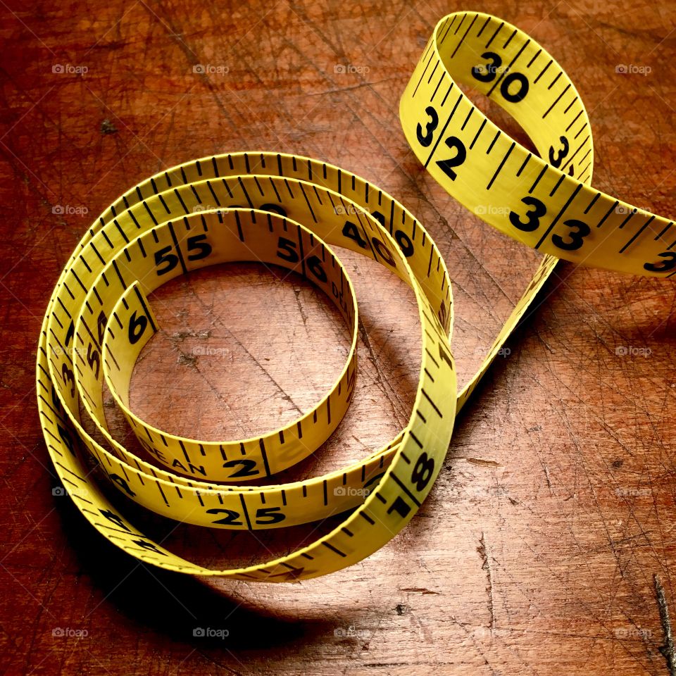 Measuring tape on antique table.