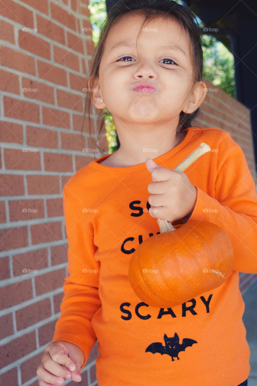 Cute girl holding pumpkin