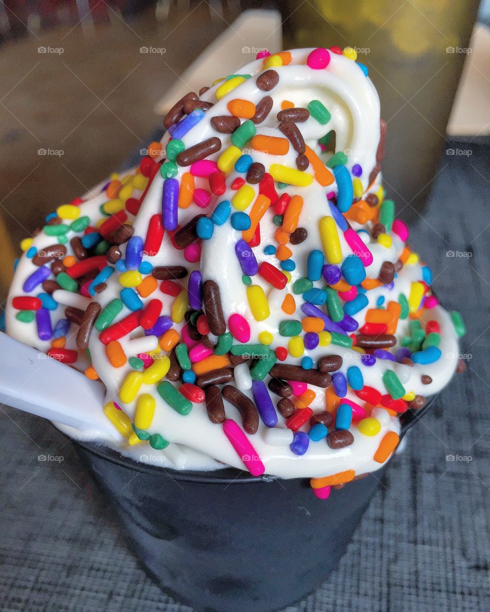 Rainbow sprinkles on vanilla ice cream 