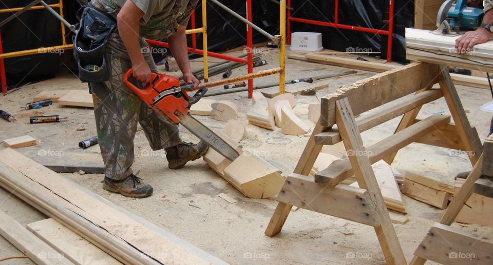 Man cutting wood using chain saw