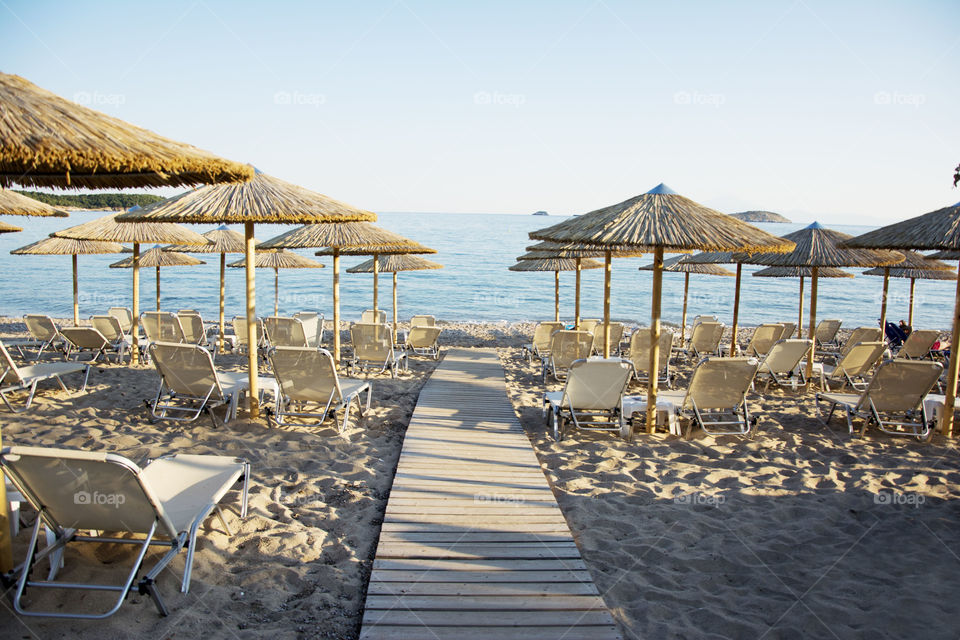 Beach at sunset. beach with deck chairs and umbrellas at sunset