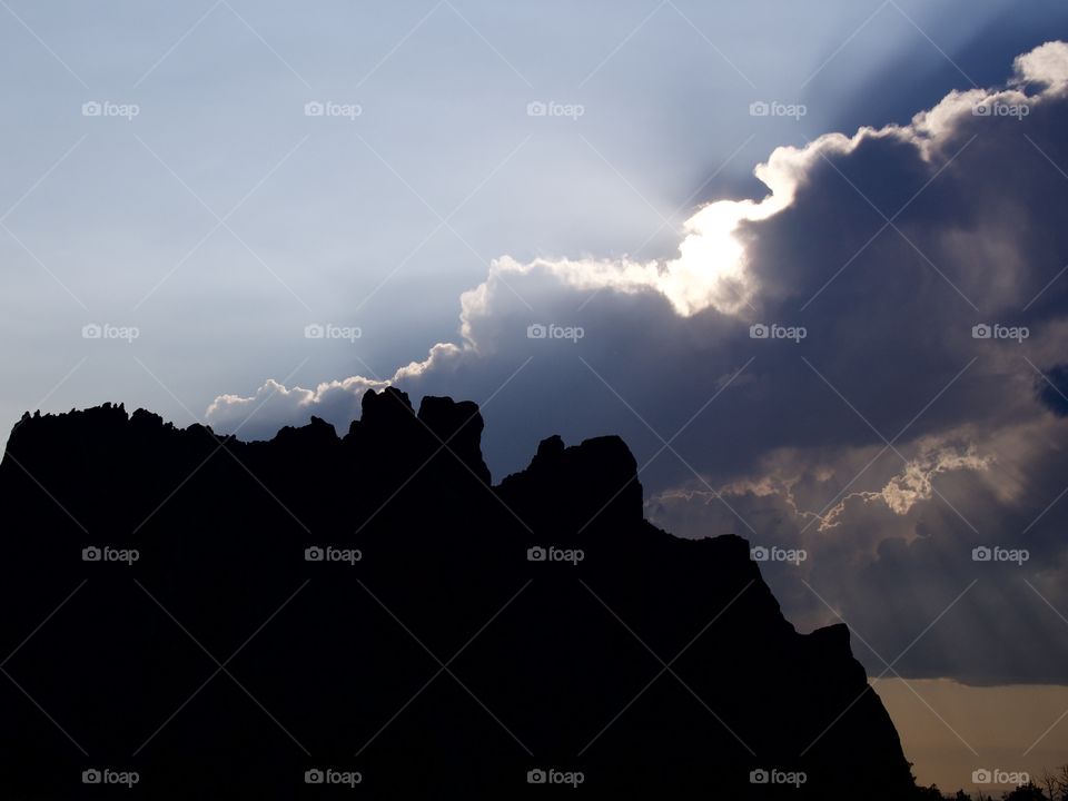 Beautiful sun rays break through the clouds after an evening summer rain storm at Smith Rocks in Central Oregon. 