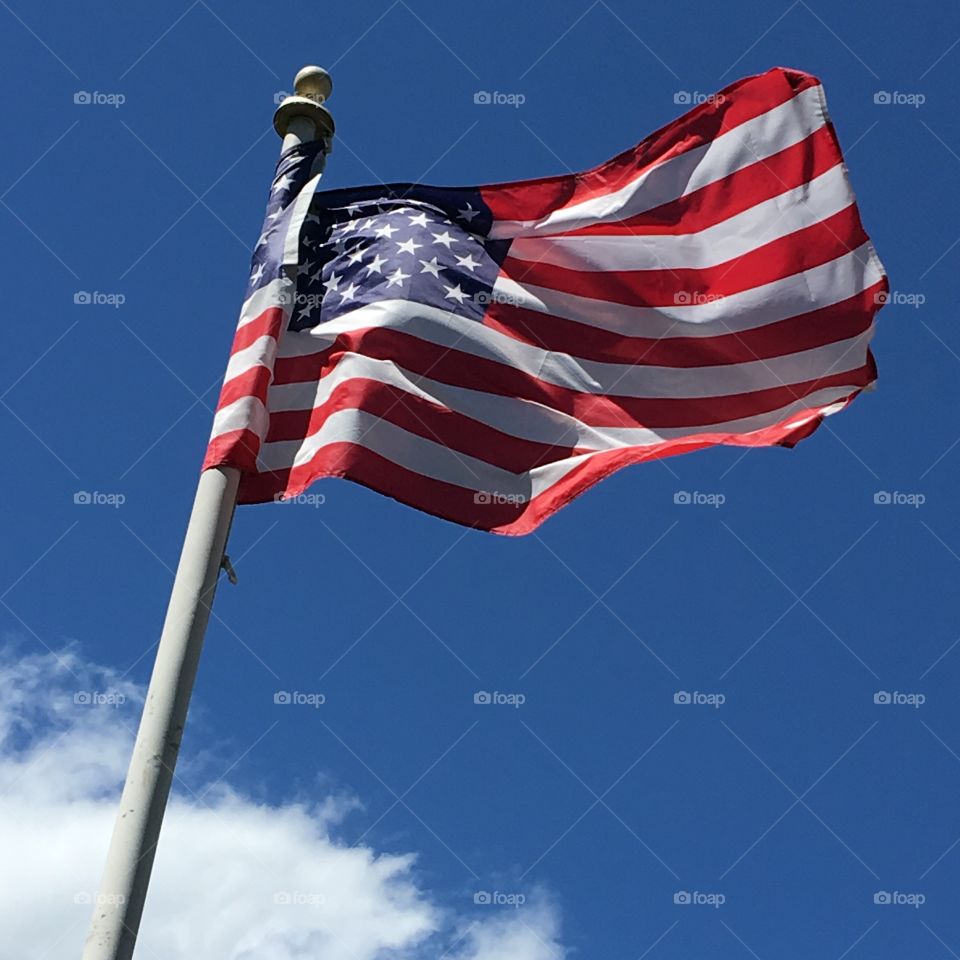 Flag on pole, wind blowing on clear day.