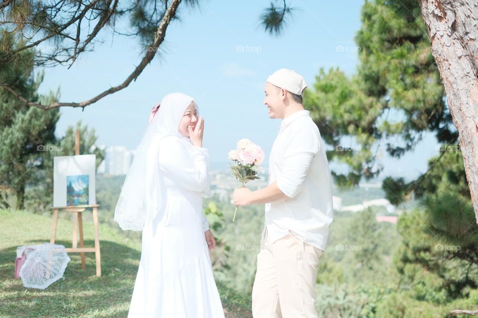 couples of newly weds wearing all white for an outdoor photoshoot.