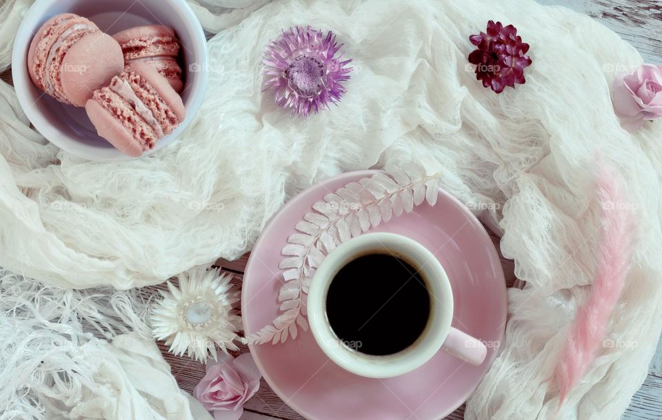 Coffee & pink macaroons flat lay with white scarf and dried flowers