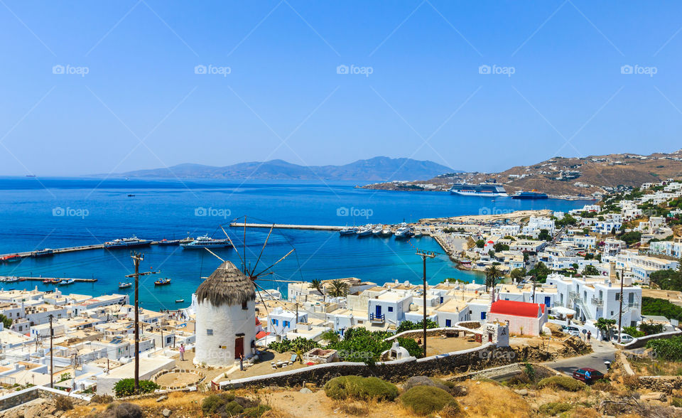 Cityscape of Mykonos, Greece. Beautiful view above city of Mykonos, Greece. Whitewashed buildings and windmills by Mediterranean sea, Mykonos island.
