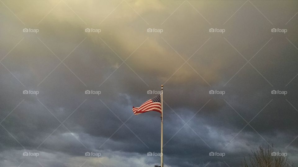 American flag with stormy sky