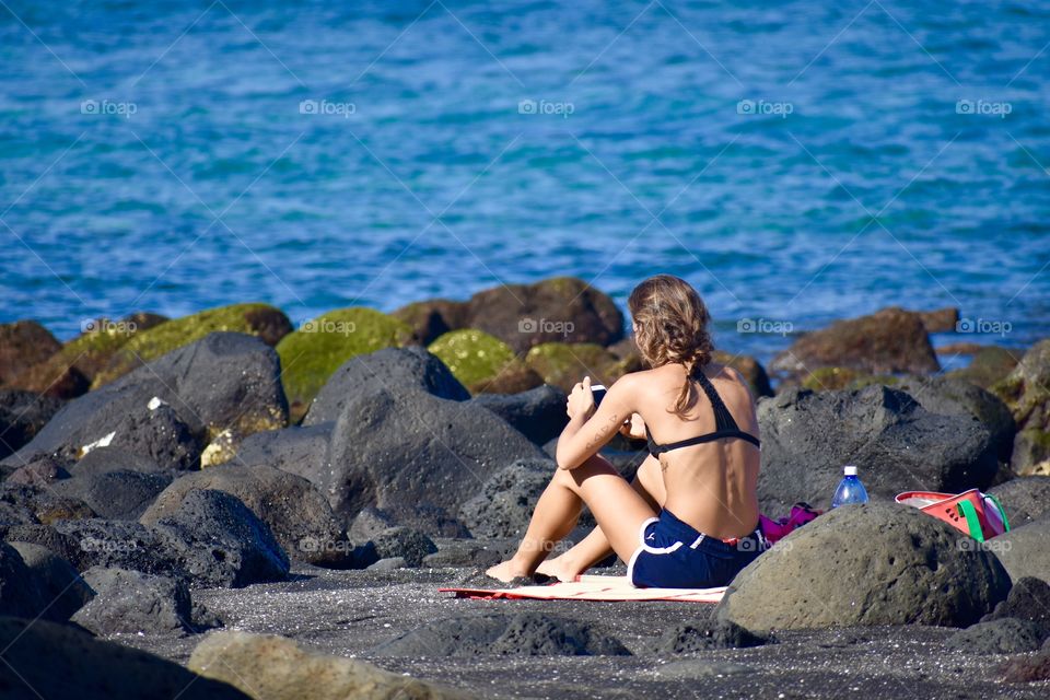 Technology everywhere, even by the ocean. Taken on the beautiful black sand and lava of Richardson Ocean Park in Hilo, Hawaii.