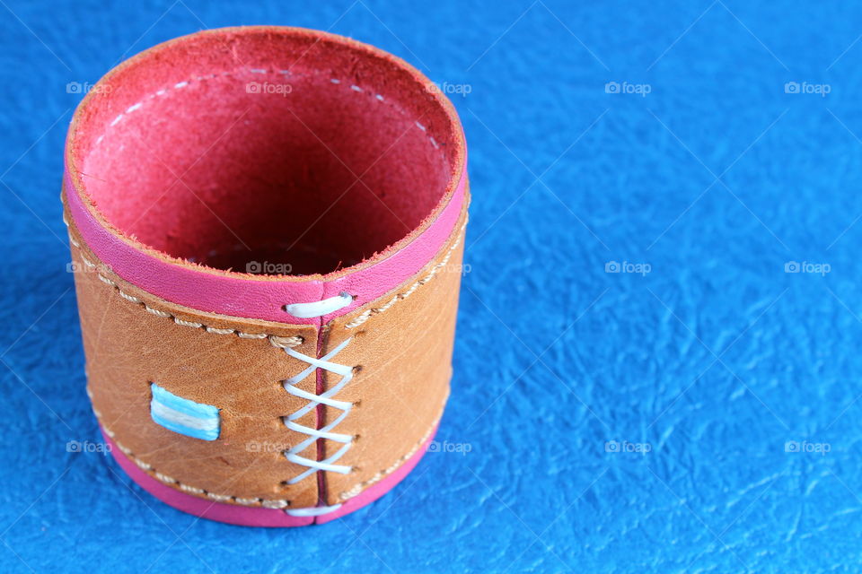 Leather strap of a perfume on a blue background