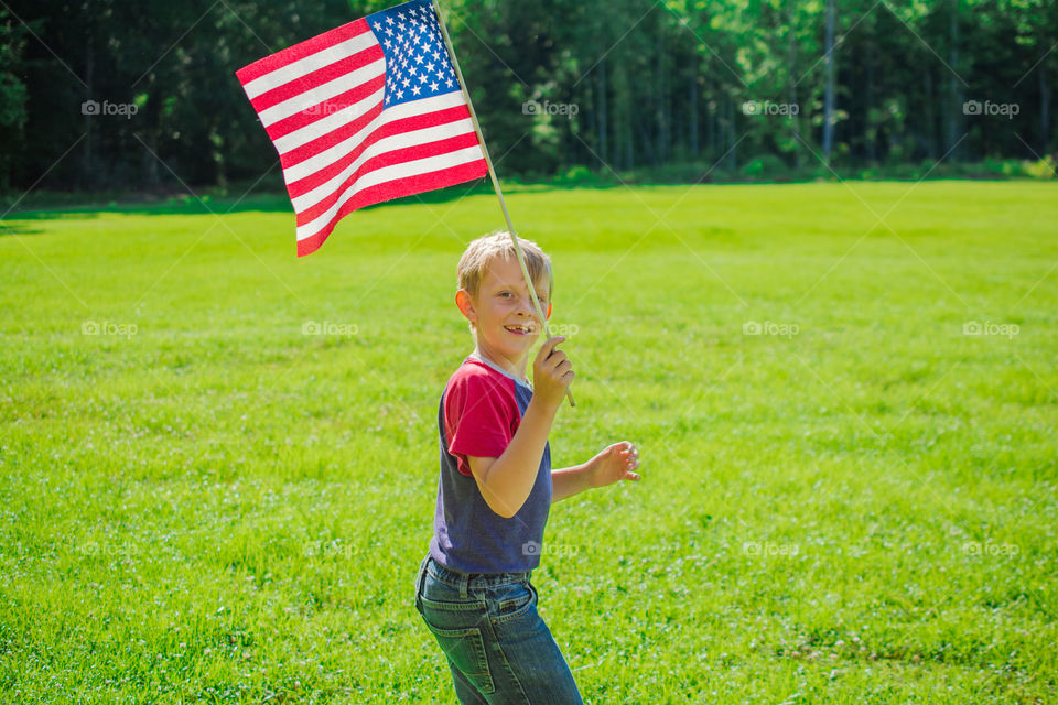 Young Boy Running with American Flag