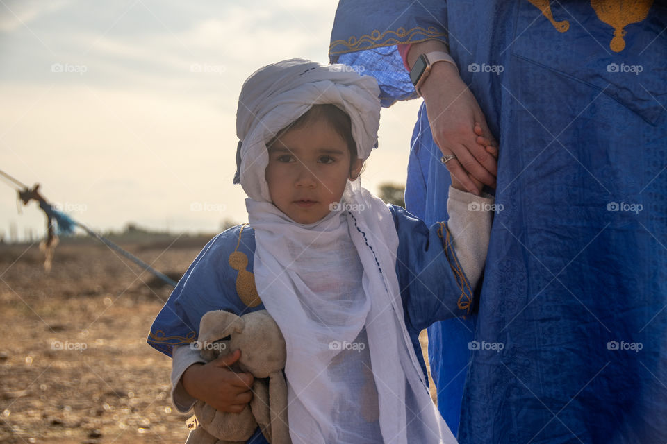 Little girl in Arabic dress holding mother’s hand