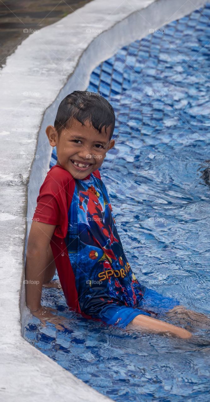 a boy who looks happy while swimming