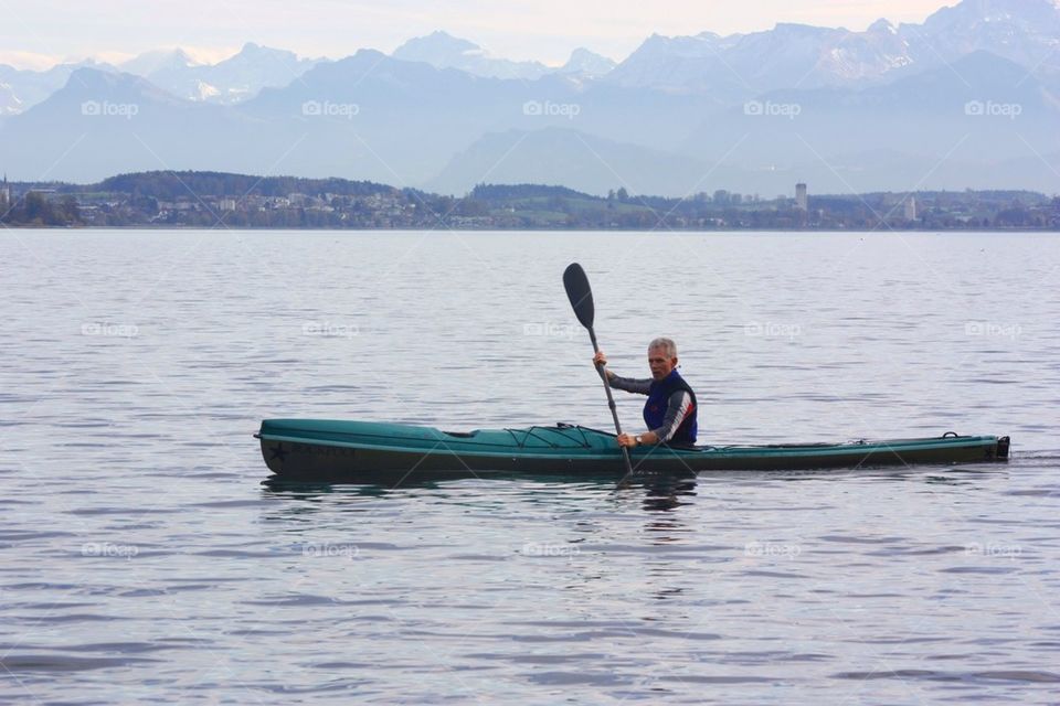 Man Rowing Kayak In Autumn In Lake