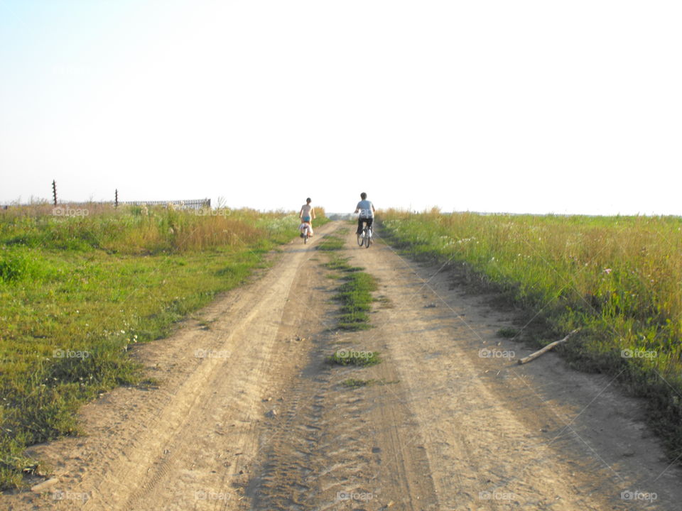 Summer, kids on their bikes along a country road