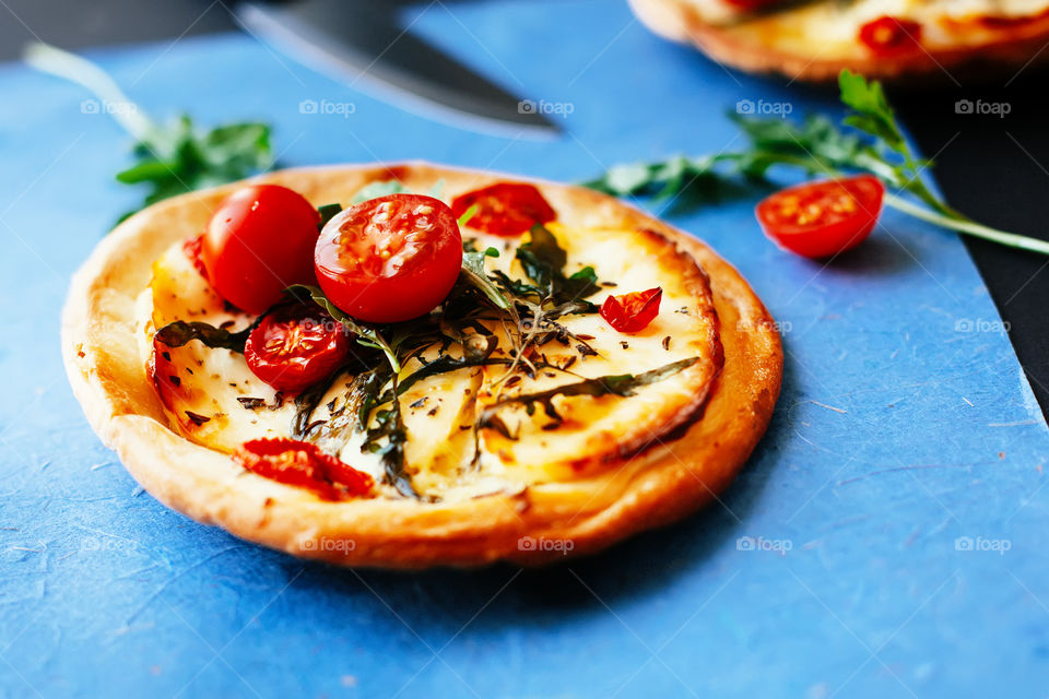 small pizza with tomatoes and rucola