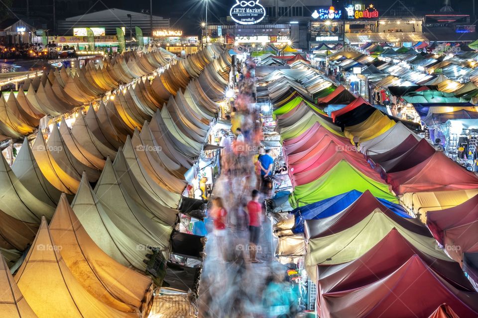 People go shopping from the colorful tents of the Bangkok night flea market