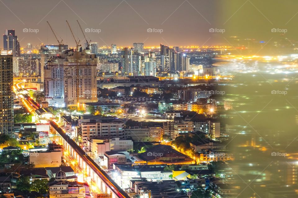 Night light and reflection of skyscraper in Bangkok Thailand