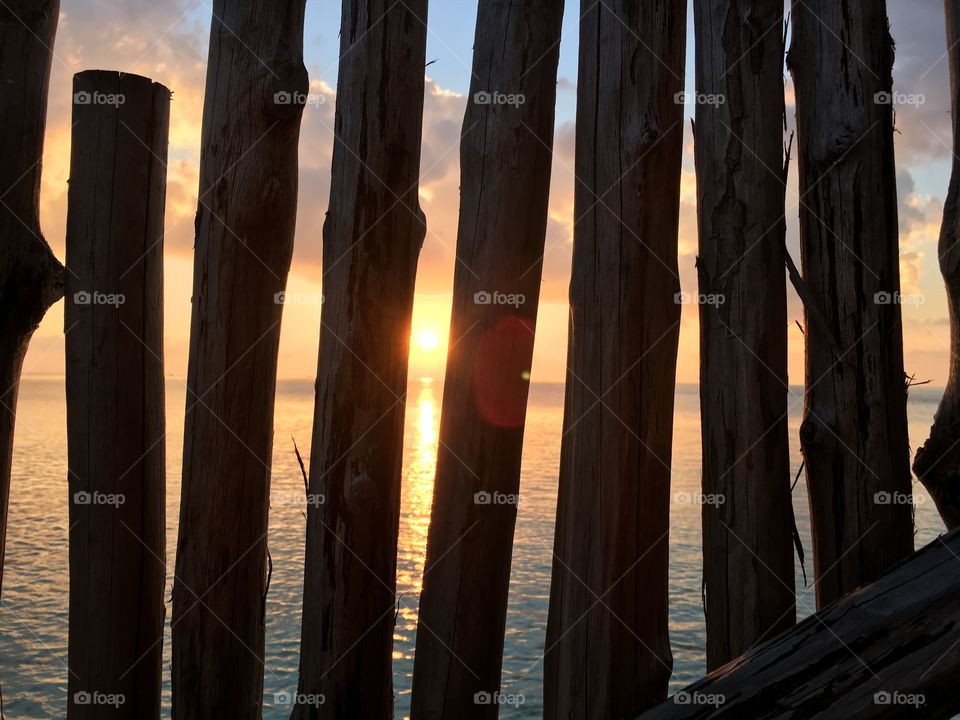 Sunset glimpsed through a fence in the Maldives. The beauty shining through. 