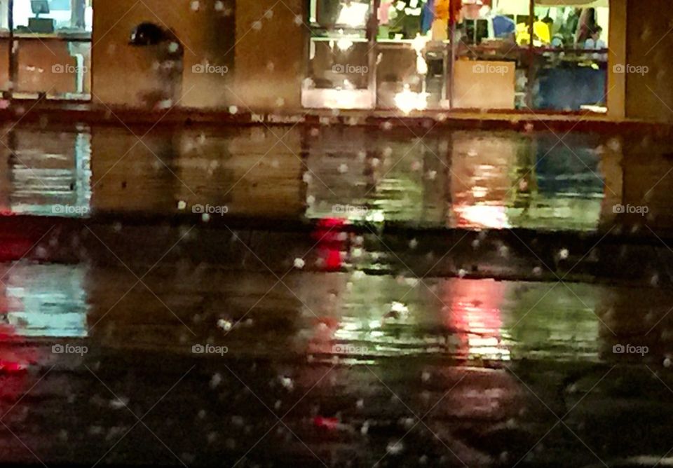 Reflections of shops on rainy night