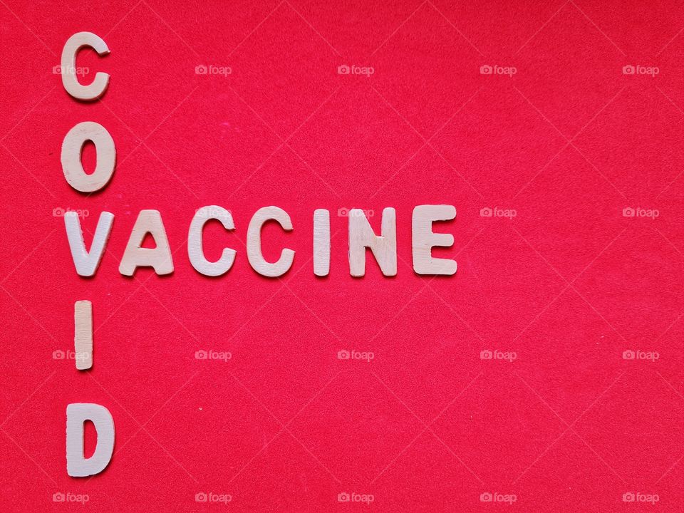 covid vaccine lettering on red background