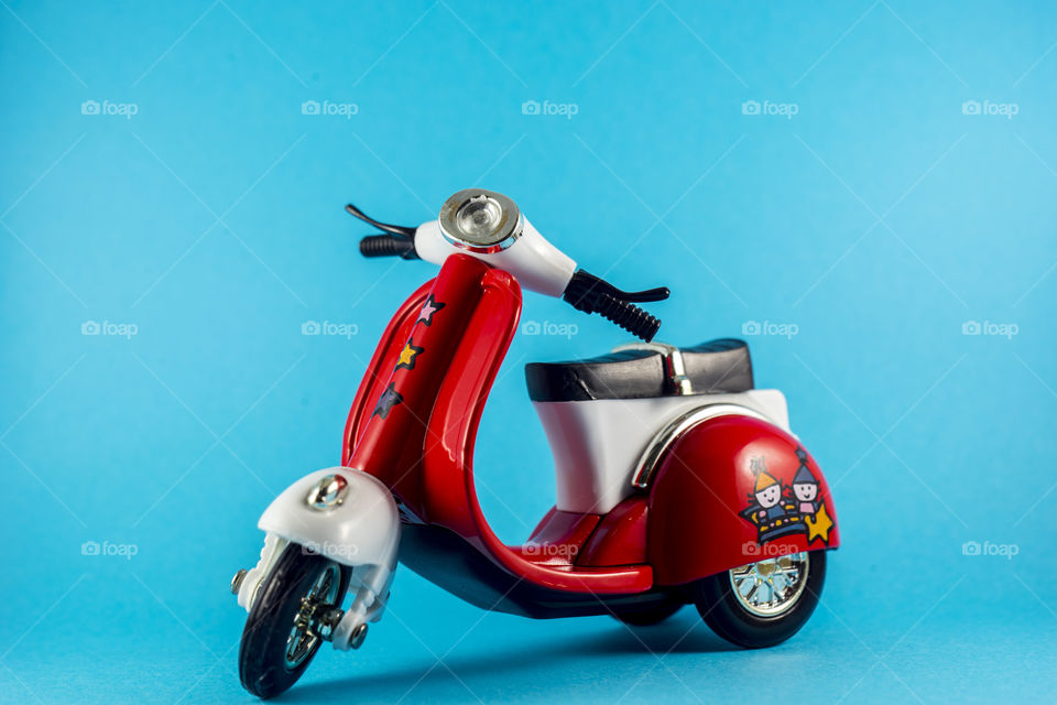 Red toy motorcycle on the blue background 