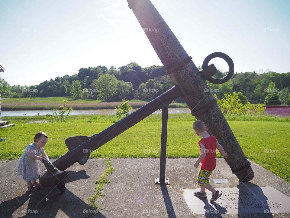 Toddler brother & sister inspecting a giant anchor.