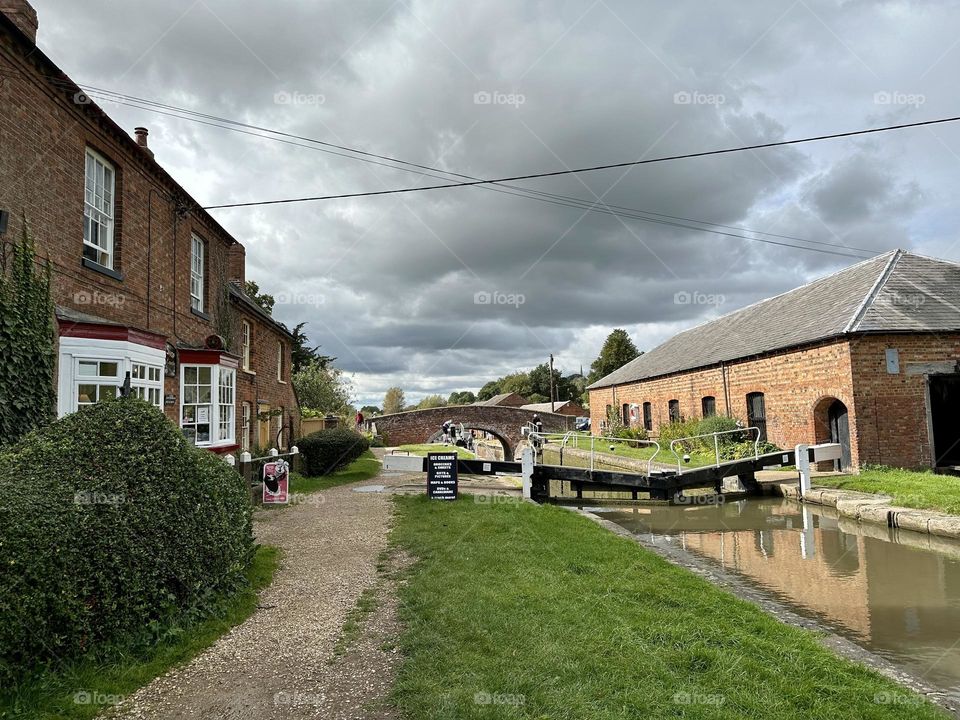 Braunston lock by canal shop on Grand Union in England towpath walk cool cloudy sky scenery weather late summer narrowboat holiday vacation scenery