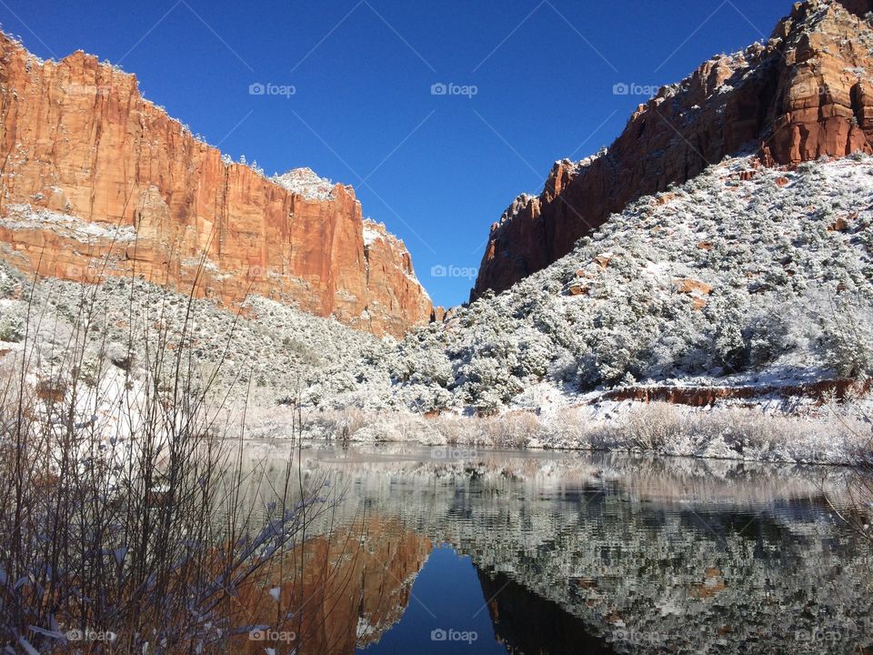 Calm Reflections. Calm reflection of snow covered sandstone cliffs in southern Utah 