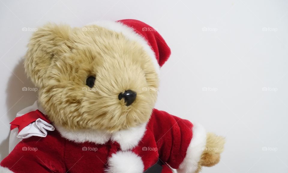 Teddy bear wearing in Santa costume - image captured from the side.
