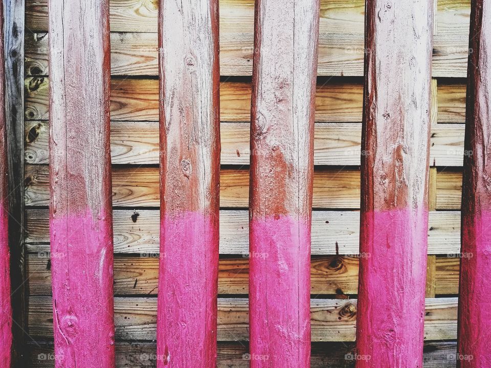 Wooden piles for the field painted in pink color